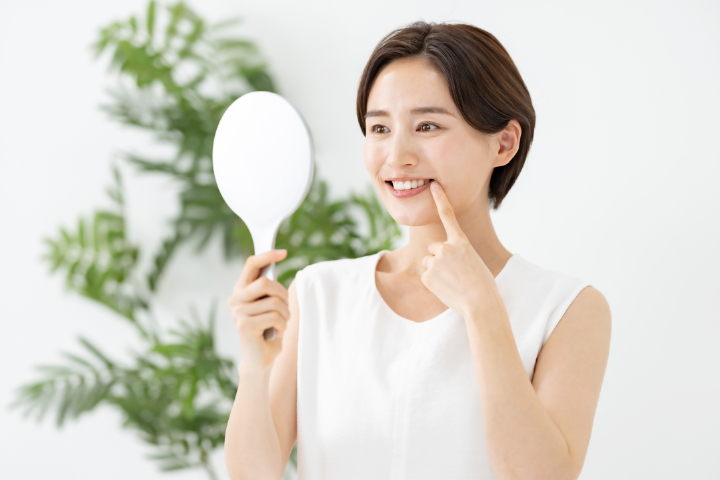 インプラントの仕上がりを鏡で確認する女性