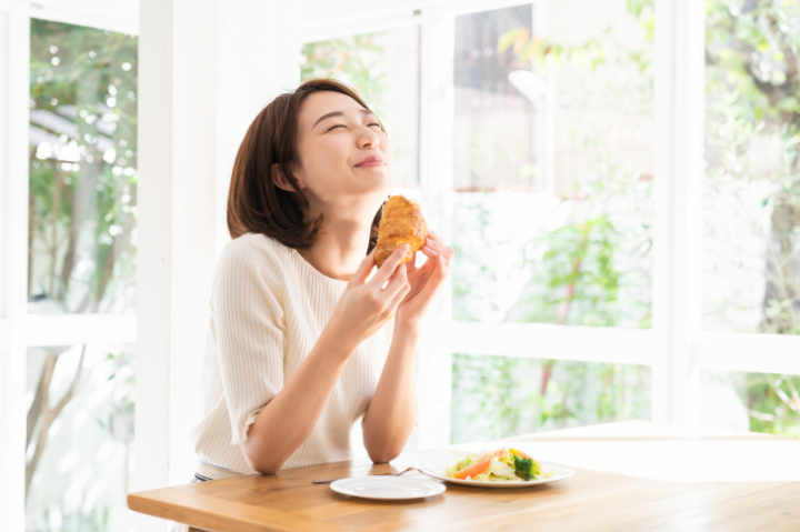根管治療をして痛みから解放され食事を楽しむ女性