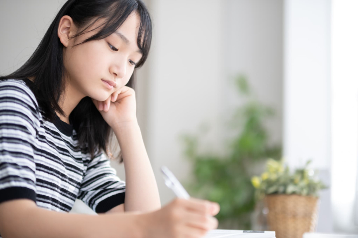 顎関節症の原因となる頬杖をつく女性