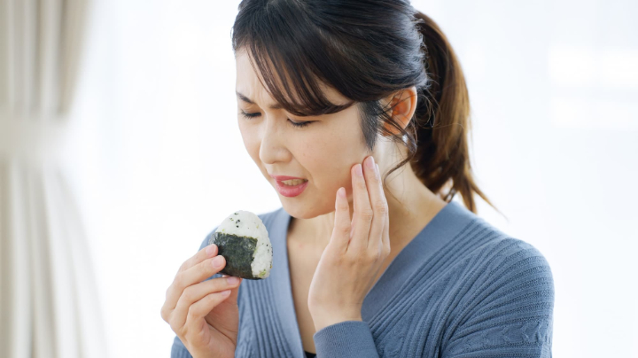 顎関節症で食事で顎が痛む女性