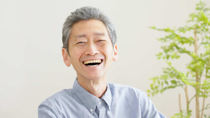 入れ歯を装着して笑顔を見せる高齢男性