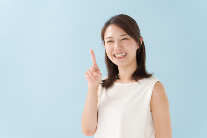 歯のセラミック治療の種類と特徴を指さし確認する女性