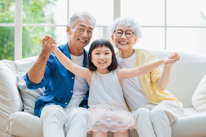 床矯正で歯列が整い笑顔を見せる子どもと家族