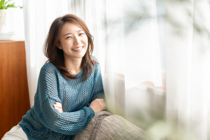 リビングでソファーにもたれリラックスする女性