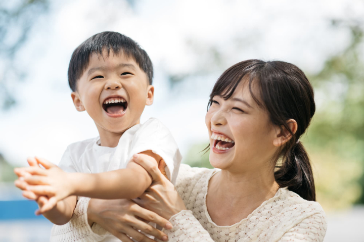 公園で楽しそうに遊ぶ親子