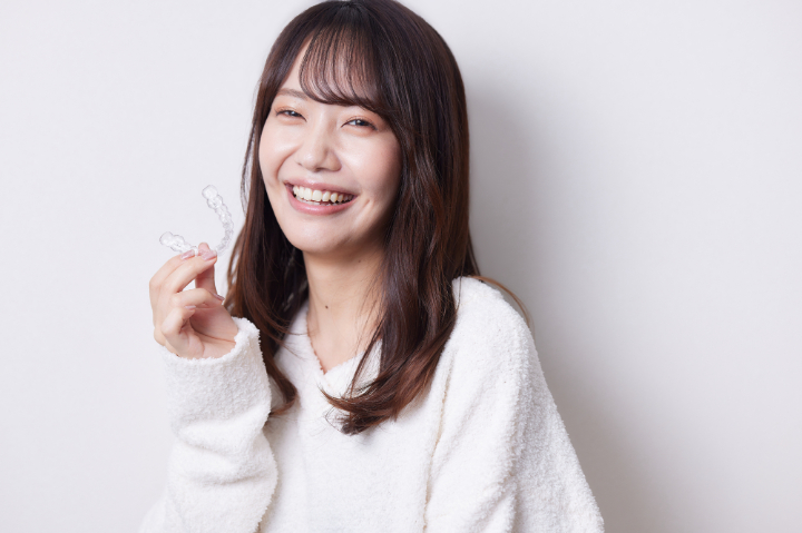マウスピースを手に笑顔の女性