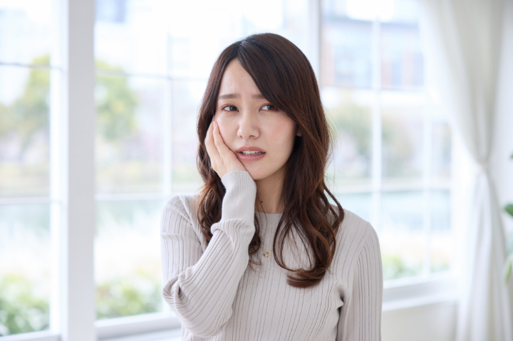 ホワイトニング後に歯がしみる女性