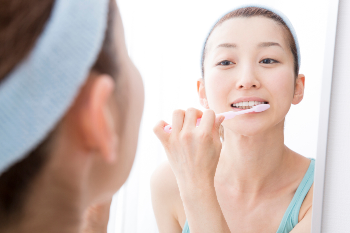 マウスピース矯正治療中に歯磨きケアする女性