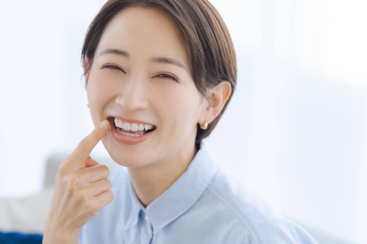 健康な奥歯を指さして笑顔を見せる女性