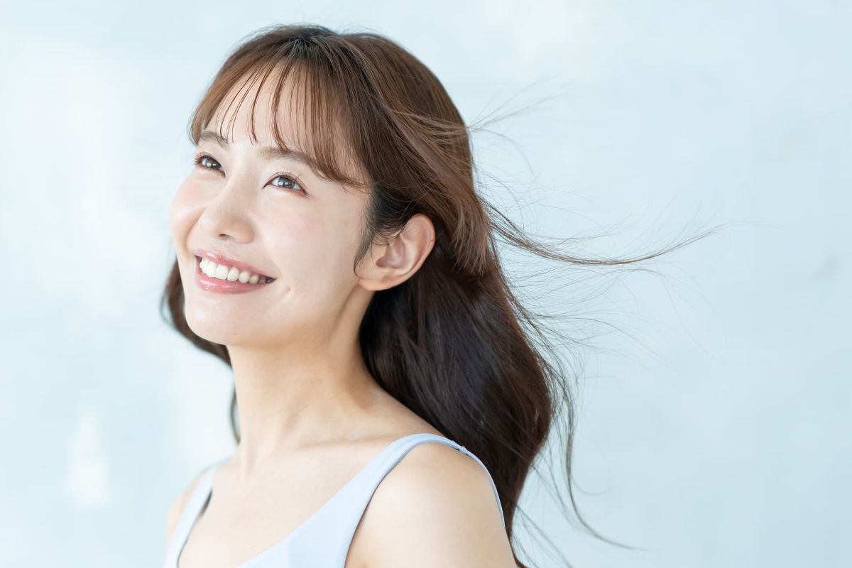 美しいセラミックの歯に満足して微笑む女性