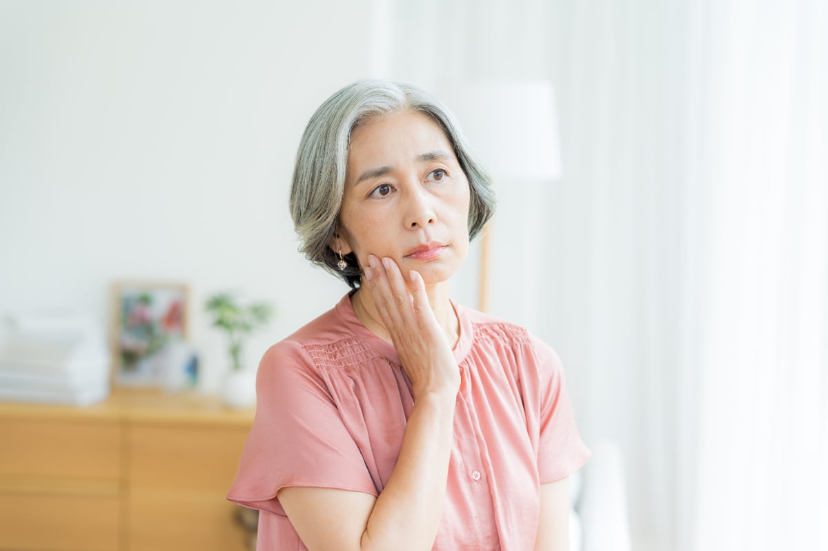 どうして入れ歯は合わなくなるのか考える高齢女性