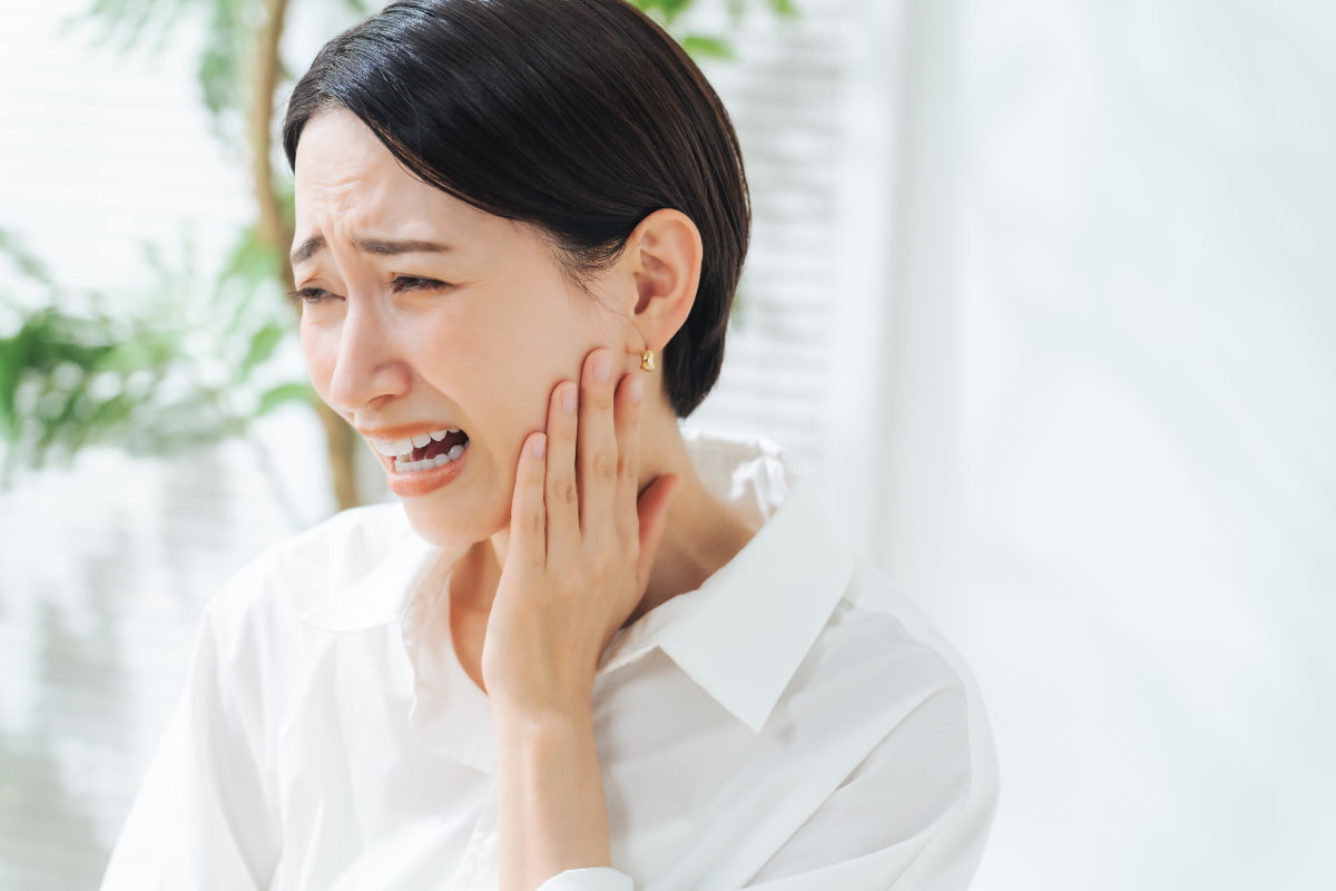 顎関節症になり顎に痛みを感じる女性