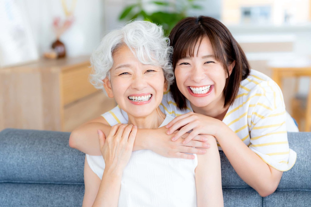 ホワイトニングをした白い歯に満足して笑う祖母と孫娘